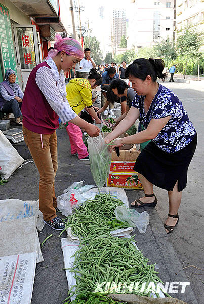 Le 8 juillet au matin, une habitante d&apos;Urumqi achète des légumes dans la rue Guangming.