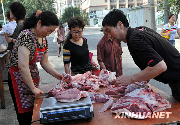 Le 8 juillet au matin, un habitant achète de la viande dans la rue Guangming.