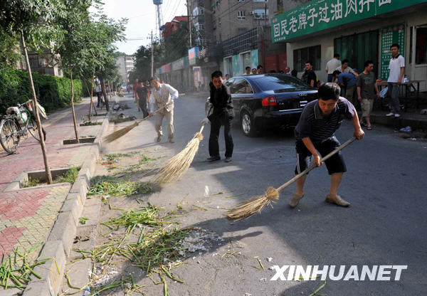 Le 8 juillet au matin, quelques habitants nettoient la rue Guangming.