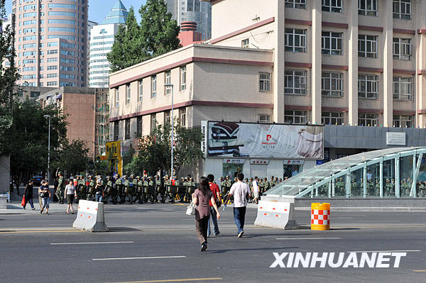 Le 8 juillet matin, une troupe de la police armée postée près d'une rue d'Urumqi.