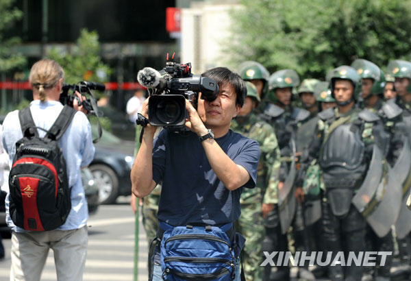 Le 8 juillet, deux journalistes d'outre-mer réalisent des vidéos dans une rue d'Urumqi.