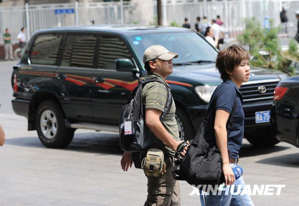 Le 8 juillet, deux journalistes taïwanais de CtiTV marchent dans une rue d'Urumqi.