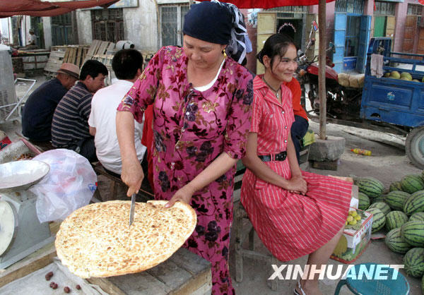 14 juillet : une Ouïgoure en train de vendre des crêpes dans le bourg de Qiman du district de Kuche.