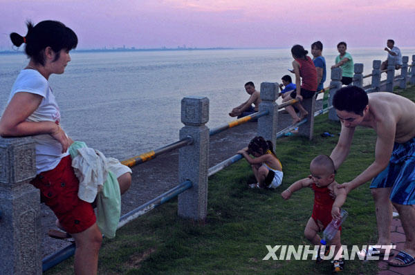 Le 19 juillet au soir, quelques habitants locaux se promènent le long du fleuve Qiantang en attendant le mascaret.