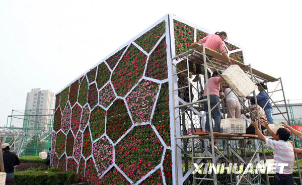 Des ouvriers en train de réaliser un parterre de fleurs à l'image du ' cube d'eau '.