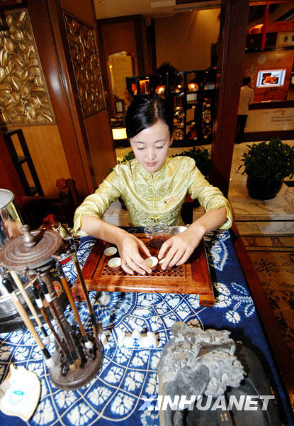 Une serveuse fait une démonstration de l'art du thé dans le hall de l'hôtel Shangri La.