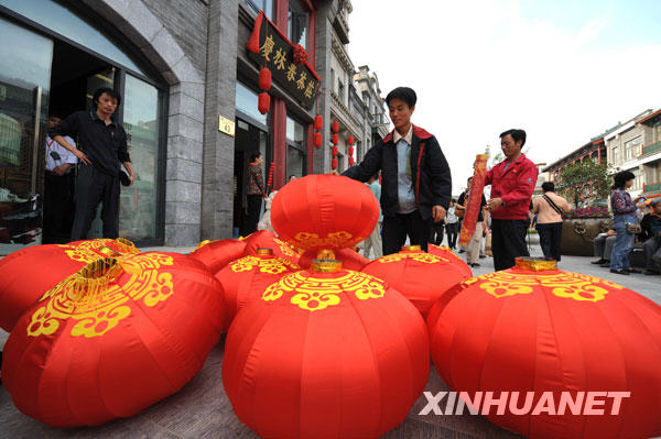 Photo : le 23 septembre, plusieurs boutiques le long de l&apos;avenue de la Porte Qianmen se sont parées de lanternes rouges pour préparer l&apos;ouverture officielle de cette rue commerçante, le 28 septembre.