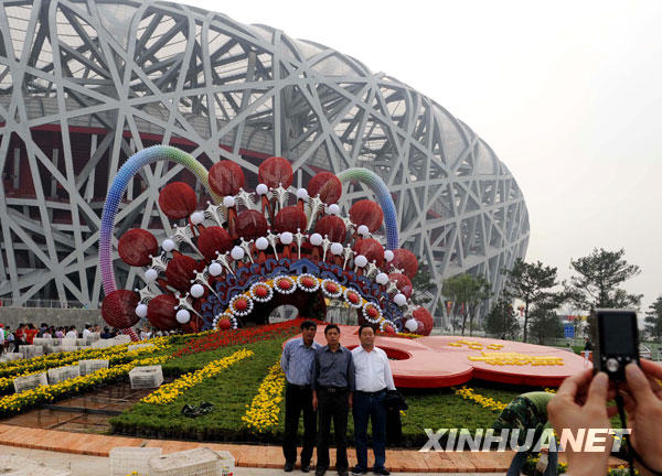 Les touristes se font prendre en photo devant la ' célébration de la Chine '.