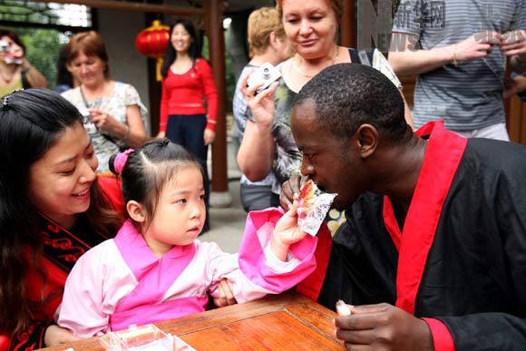 Le 27 septembre, dans le parc de loisir Beijing World Park, Duan Tingting, une fillette chinoise offre un gâteau de lune à Richard, un touriste ougandais.