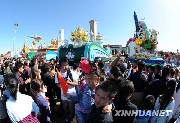 Le 3 octobre, des touristes prennent des photos devant les chars de fleurs sur la place Tian'anmen.