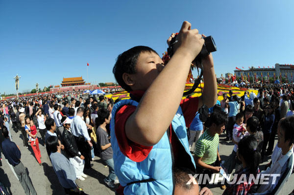 Le 3 octobre, des touristes prennent des photos devant les chars de fleurs sur la place Tian&apos;anmen.