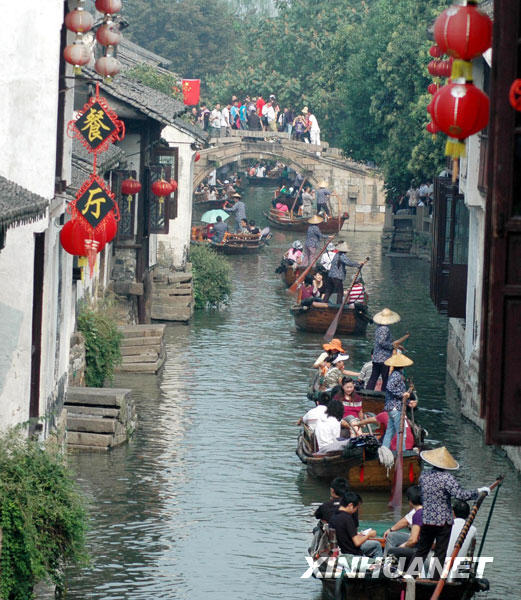 Le 3 octobre, quelques touristes visitent en bateau le bourg antique de Zhouzhuang dans la province de Suzhou.