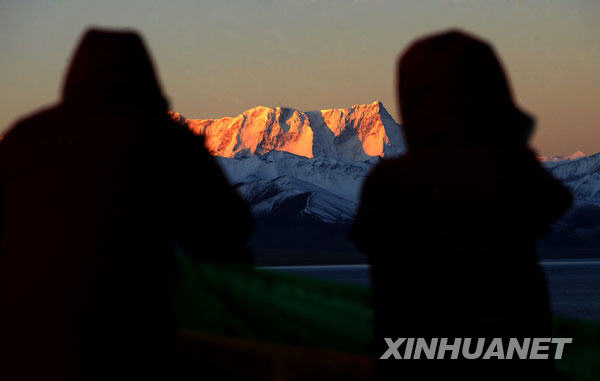 Deux touristes prennent des photos du lever de soleil sur le mont Nyainqentanglha. Photo prise le 28 septembre.