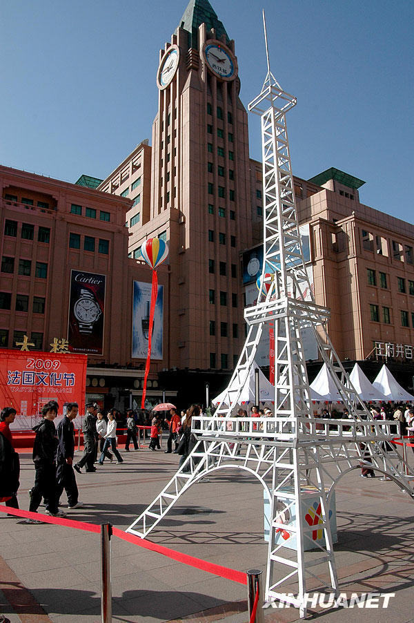 Le 17 octobre, des passants devant un modèle réduit de la tour Eiffel exposé dans la rue commerçante Wangfujing.