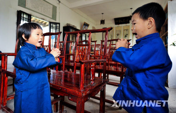 Le 26 octobre, des enfants vêtus de l'uniforme de l'école se saluent selon la coutume dans une classe de l'école chinoise traditionnelle Yuzhang. 