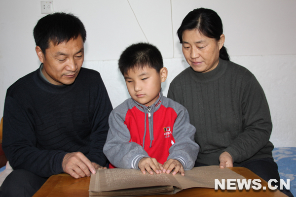 Liu Hao (centre), un garçon aveugle de 8 ans apprend le braille.