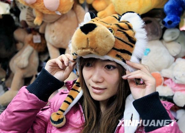 Le 15 novembre, une jeune femme essaie un bonnet en forme de tigre. 