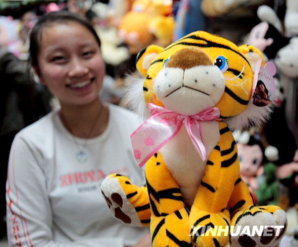 Une vendeuse présente un adorable tigre en peluche.