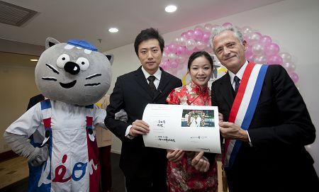 Photo de groupe du couple de jeunes mariés, M. José Freches, président de la COFRES et Léon, mascotte du Pavillon France.
