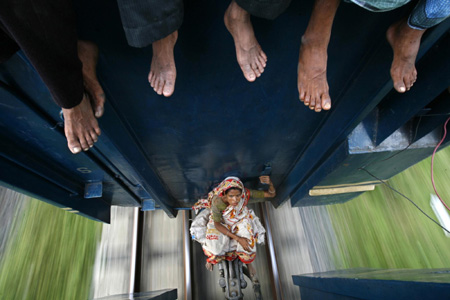 Le 20 septembre 2009, une femme assise entre les wagons du train qui part de Dhaka pour Mymensing. Des millions de résidents de Dhaka rentrent chez eux pour célébrer la fête musulmane de lEid al-Fitr.