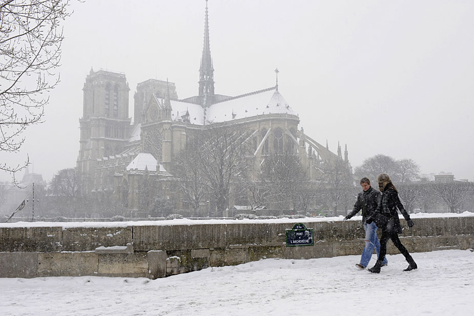 Le 17 décembre, les piétons marchent sur la chaussée enneigée devant Notre-Dame. 