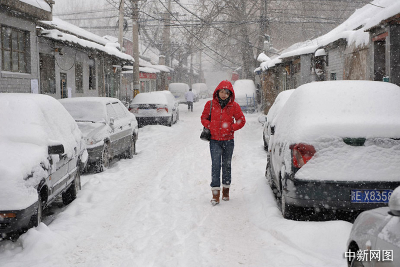 Une jeune femme marche précipitamment dans une ruelle. 