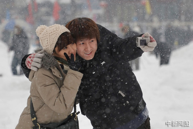 Un couple se fait photographier sous la neige à Shichahai. 