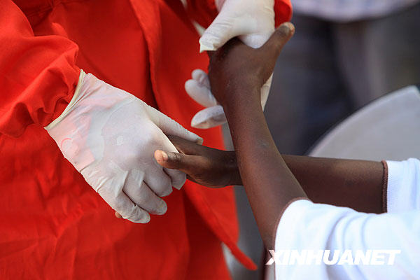 Le 14 janvier, un médecin chinois prend la main d'un enfant de Port-au-Prince et tente de le réconforter.
