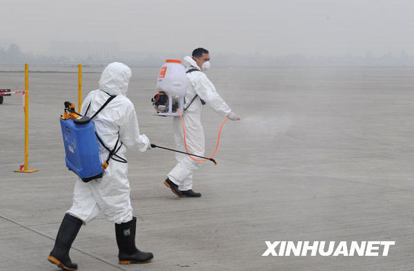 Avant l'arrivée de l'avion transportant les pandas, des employés aseptisent la piste d'atterrissage.