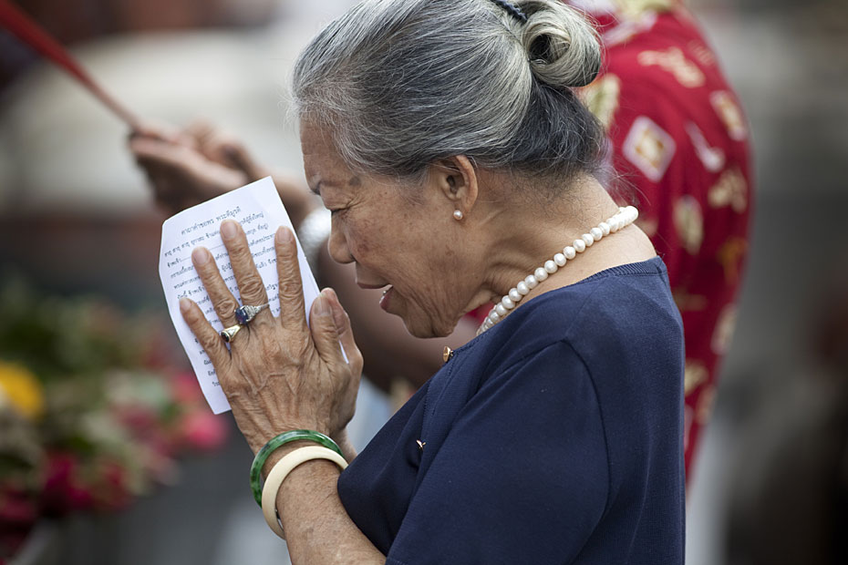 Une vieille dame prie pour une bonne année dans un temple en Indonésie.