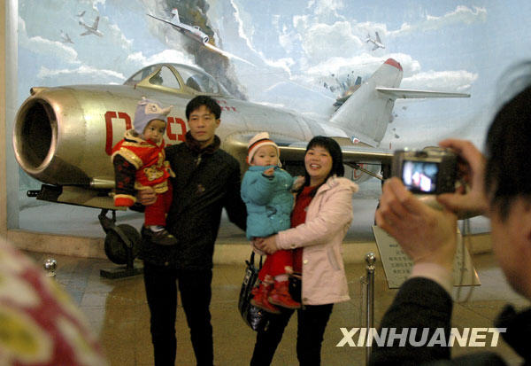 Le 18 février, des touristes posent pour une photo dans le musée militaire du peuple chinois.