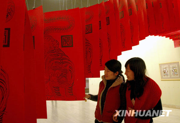 Le 17 février, deux visiteuses admirent de près des estampes lors de l'exposition des estampes du Nouvel An chinois.