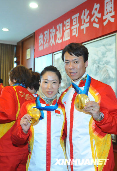 Le 2 mars, Shen Xue et Zhao Hongbo, médaillés d'or de patinage artistique couples montrent leurs médailles d'or. 