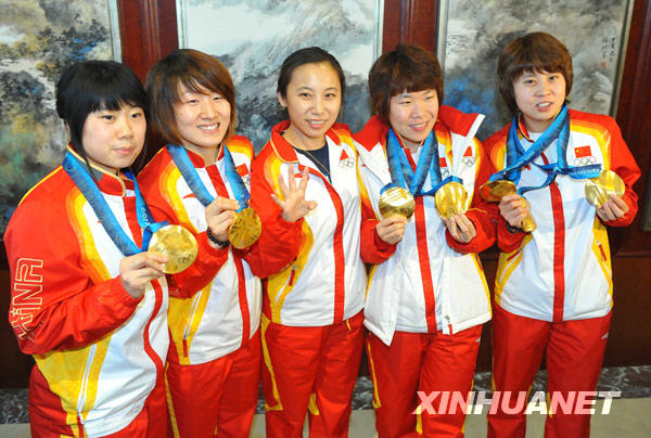 Le 2 mars, Wang Meng, Zhou Yang, Sun Linlin et Zhang Hui, médaillées d&apos;or de patinage de vitesse sur piste courte - Relais 3 000 m dames posent pour une photographie avec leur entraîneur Li Yan (centre). 