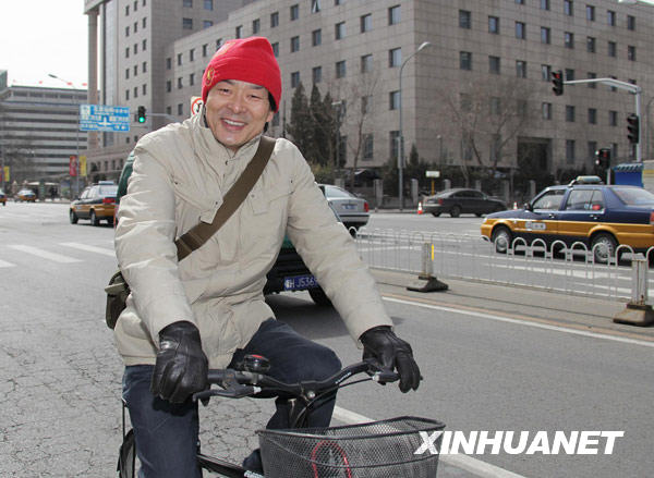 Le 2 mars, Pu Cunxin, membre de la CCPPC et célèbre acteur chinois, arrive en vélo au Beijing International Hotel pour confirmer sa présence sur le registre de la session annuelle de la CCPPC.