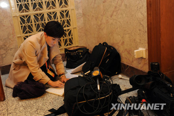 Un journaliste rédige son article à l&apos;intérieur du Grand Palais du Peuple. 