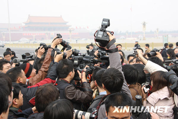 Avant la cérémonie d&apos;ouverture, un membre de la CCPPC est entouré par les journalistes. 