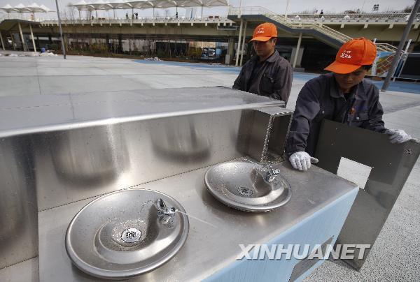 Deux techniciens ajustent les points d'eau potable.