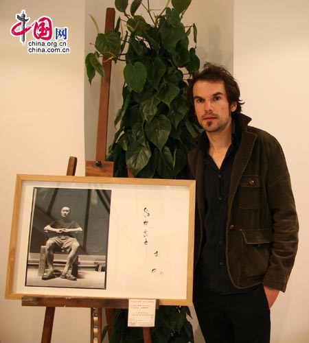 Alexis Mestre et l'un de ses portraits des 108 artistes chinois.
