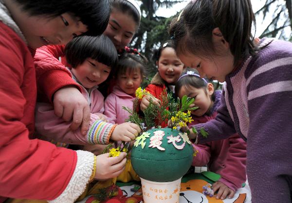Le 19 avril, des enfants décorent un modèle réduit de la terre avec des matériaux plastiques. 
