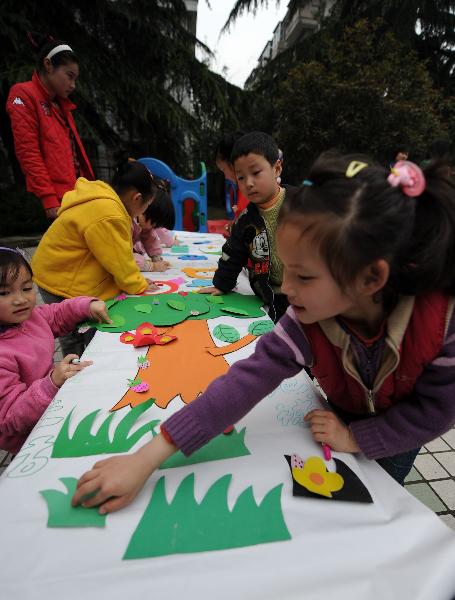 Des enfants fabriquent une forêt avec du papier recyclé et des matériaux plastiques. 