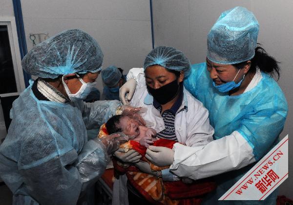  Des infirmières de la maternité de Yushu portent soigneusement le bébé. 