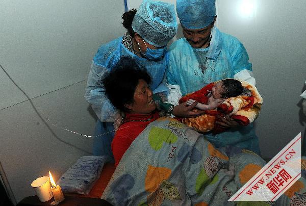 Des infirmières portent le bébé à sa mère. 