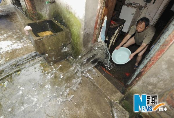 Le 18 mai, un habitant de la ville de Nanchang, dans la province du Jiangxi, balaie l'eau qui a inondé sa maison. 