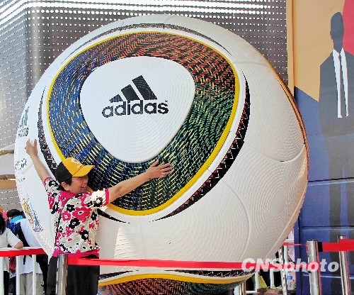 Dans le pavillon de l'Afrique du Sud, un visiteur pose avec le ballon officiel de la Coupe du monde 2010. 