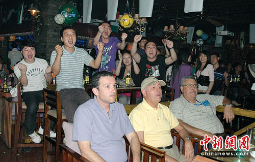 Guangxi : Le 11 juin au soir, dans un bar de Guilin, des supporteurs locaux et brésiliens regardent le match d'inauguration de la Coupe du monde.