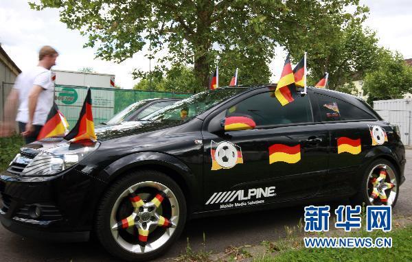 Un supporteur allemand décore sa voiture de drapeaux de son pays.