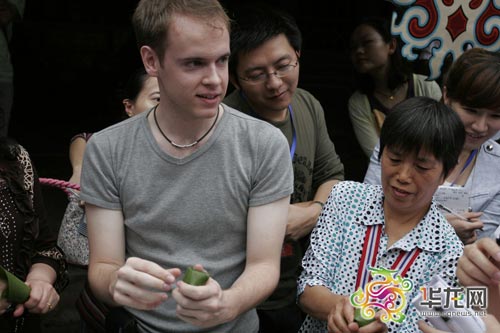 Des touristes étrangers apprennent aussi à faire des zongzi auprès des habitants locaux.