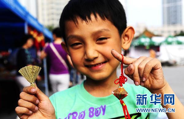 Le 14 juin, un jeune garçon montre le « sachet parfumé » et le « petit balai » qu'il a choisis à la foire du temple impérial de Shenyang pour la fête des Bateaux-Dragon, fête traditionnelle qui tombe cette année le 16 juin.