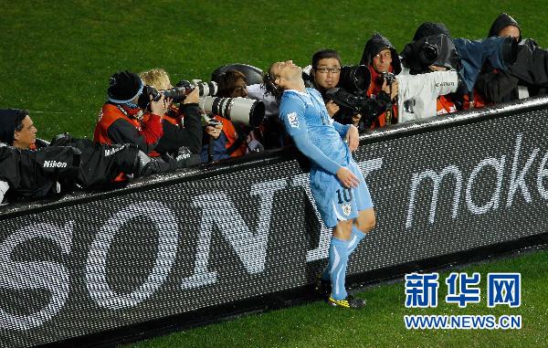 Le 10 juillet, Diego Forlan, joueur de l&apos;équipe d&apos;Uruguay, se repose contre une enseigne publicitaire. 